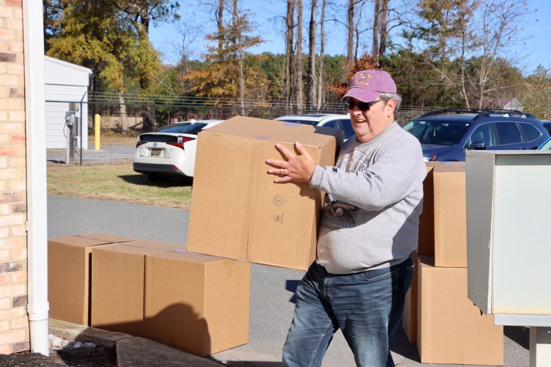 Ed Hoffman is among the volunteers carrying boxes off the truck.